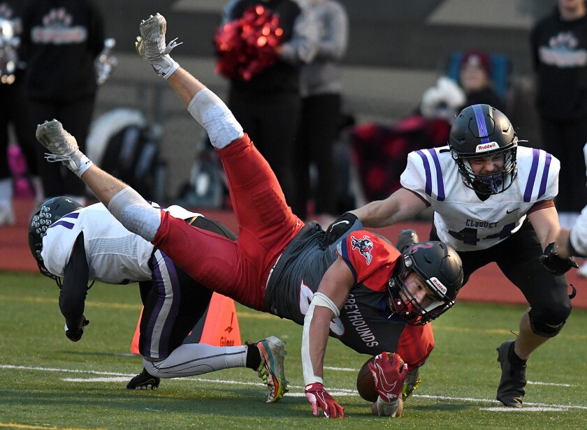 Cloquet’s Dayne Painovich (2) and Carter Horvat (44) knock Duluth East’s Austan Orvedahl (2) off his feet