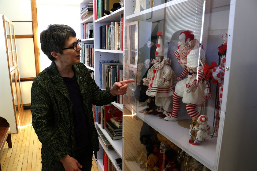 Woman describes doll figures of clowns on display.