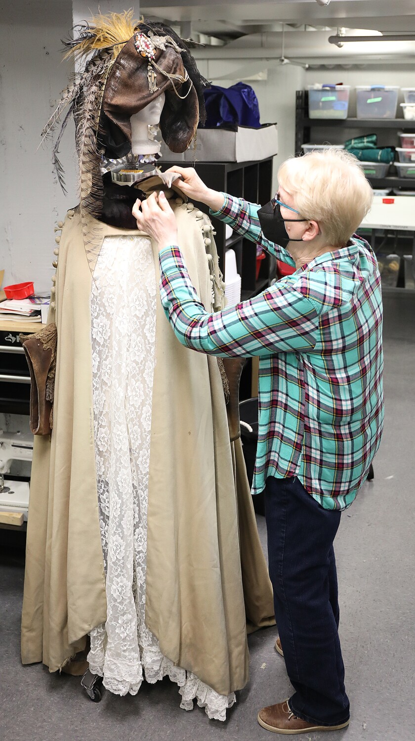 Peg Ferguson, the costume shop manager for the Duluth Playhouse, unbuttons the jacket worn on stage by Angela Lansbury in Dear World