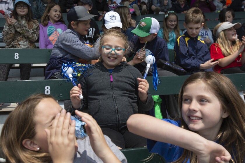 Fourth grader Greta Pritchard, center, cheers as her friends Lexis Kolar and Kendra Kush goof off at the Duluth Huskies' annual Education Day on Monday at Wade Stadium. Ellen Schmidt / eschmidt@duluthnews.com