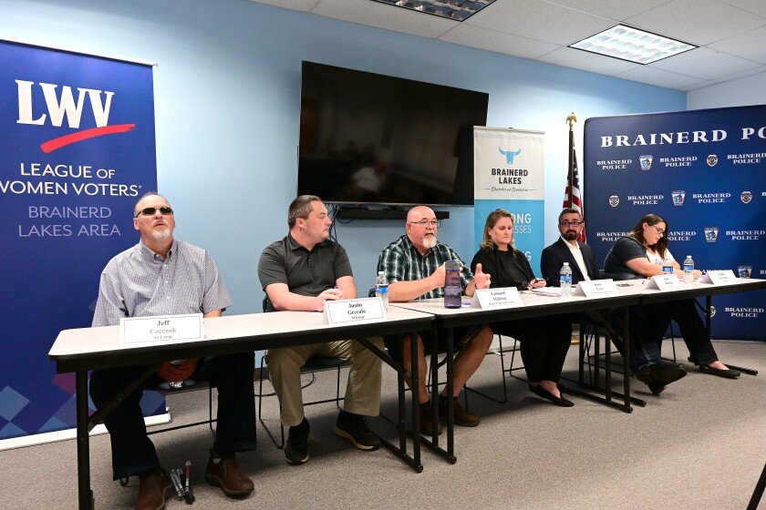 Six candidates for Brainerd City Council sit together at a long table during a candidate forum