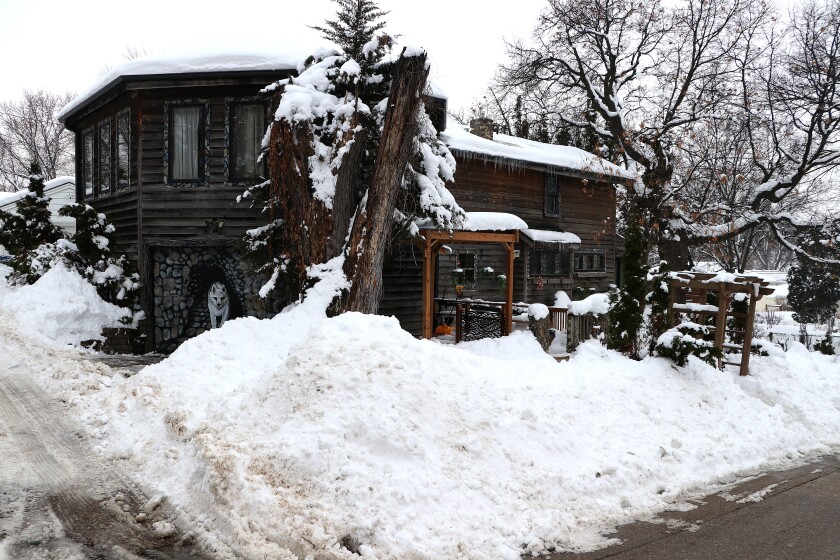 Snow covered house with a wolf painted on garage door.