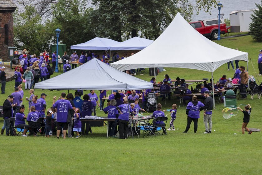 People in purple shirts celebrate recovery in outdoor park