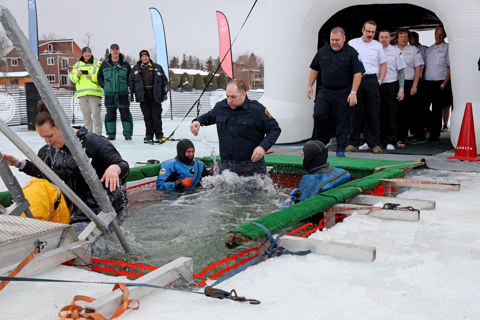 People jump into the water during the Polar Plunge event on Pelican Lake.