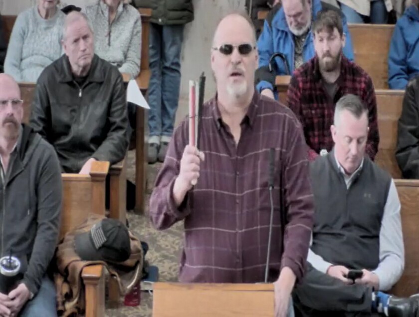 Man stands on the podium at a public meeting