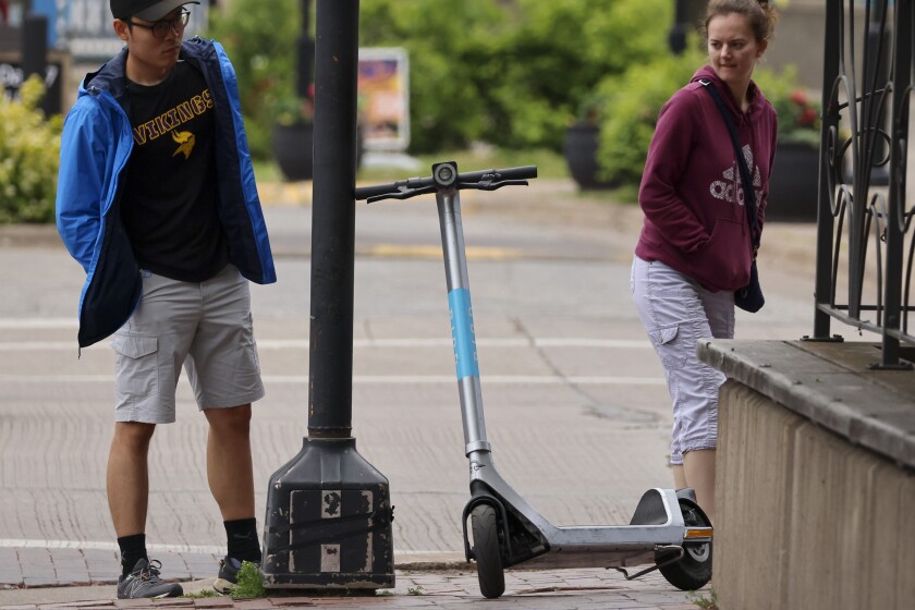 Empty scooters sitting on sidewalk