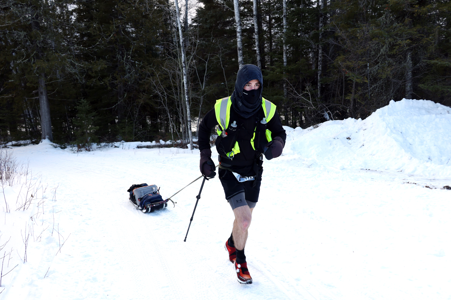 Ultramarathoner runs in shorts along snowy trails