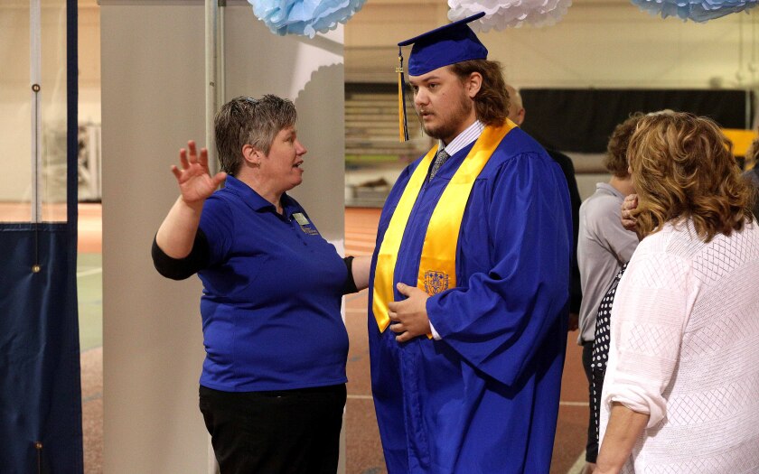 Dean of Students gives instructions to a graduate