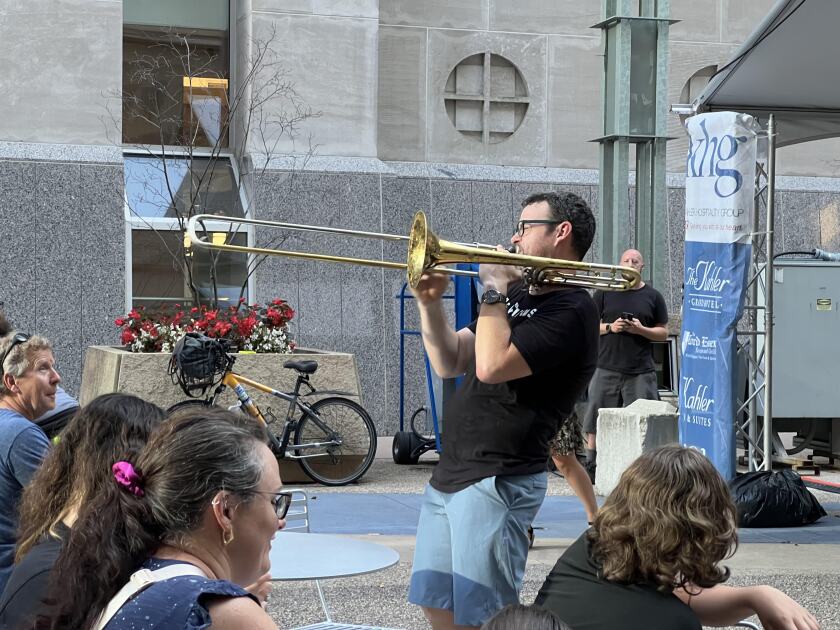 A man playing a trombone at a music celebration.