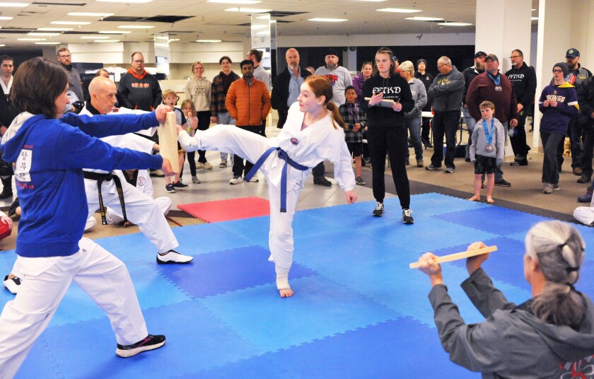 Martial arts student breaking boards