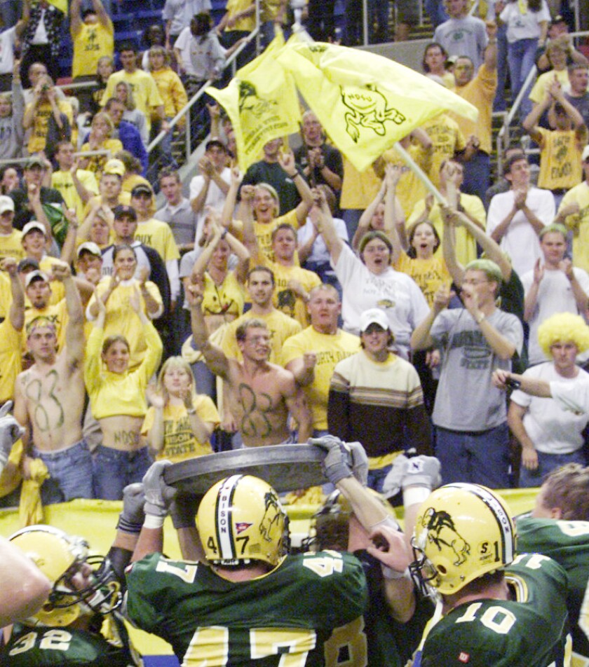 Bison fans celebrate NDSU's football victory over UND with the nickel trophy at the Fargodome Sept. 30, 2000. Colburn Hvidston III / Forum News Service