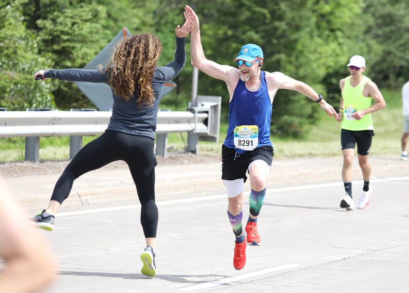 Pete Bromen (8291) of Duluth jumps as he gives a high five to Emily Saul