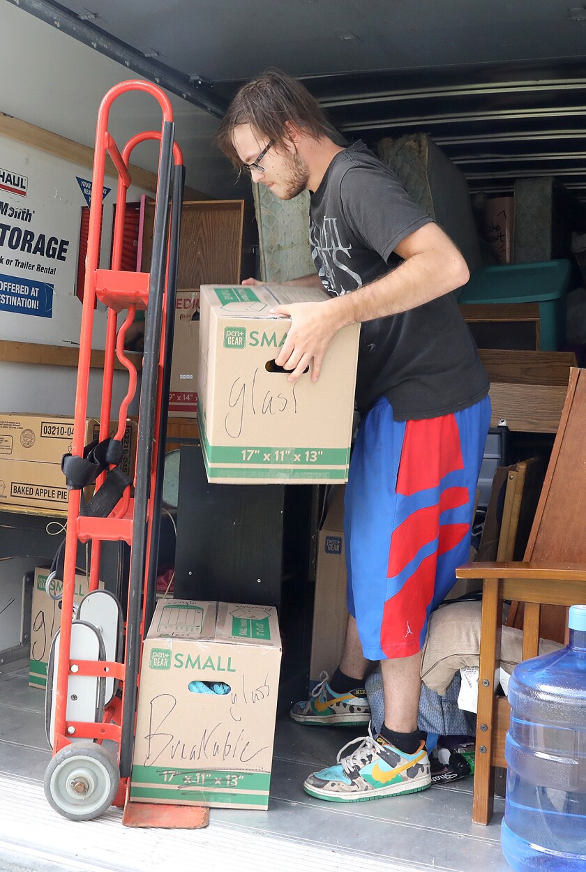 Zach Stirewalt, formerly of Cloquet, loads a dolly as he moves his mother-in-law to an apartment in Duluth