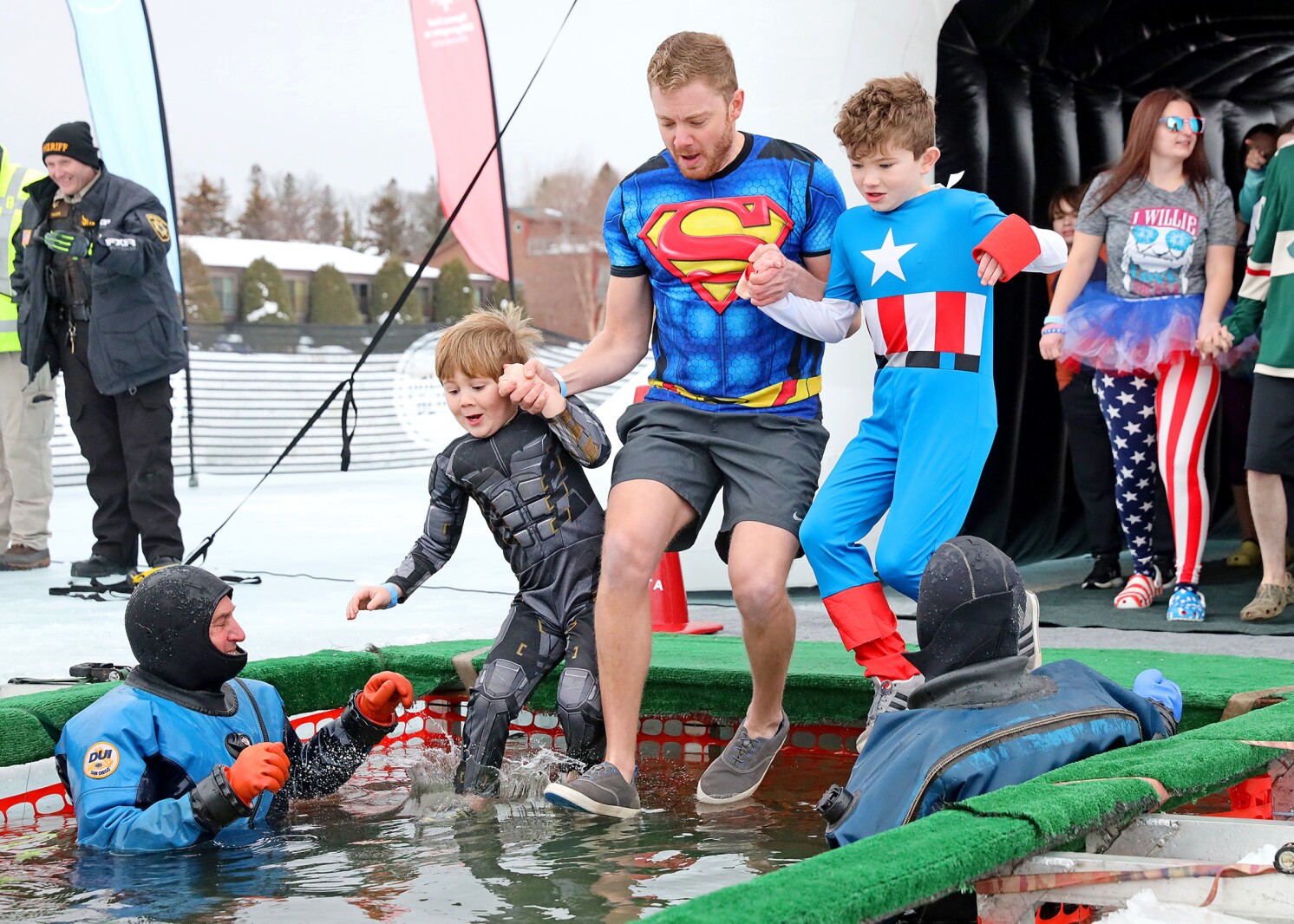 People jump into the water during the Polar Plunge event on Pelican Lake.