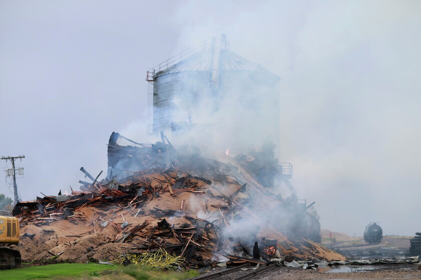Thousands of bushels of wheat spill out of a debris pile at the scene of an early morning fire at the Kennedy Farmers Elevator Co. in northwestern Minnesota on Wednesday. photo by Eric Hylden/Grand Forks Herald