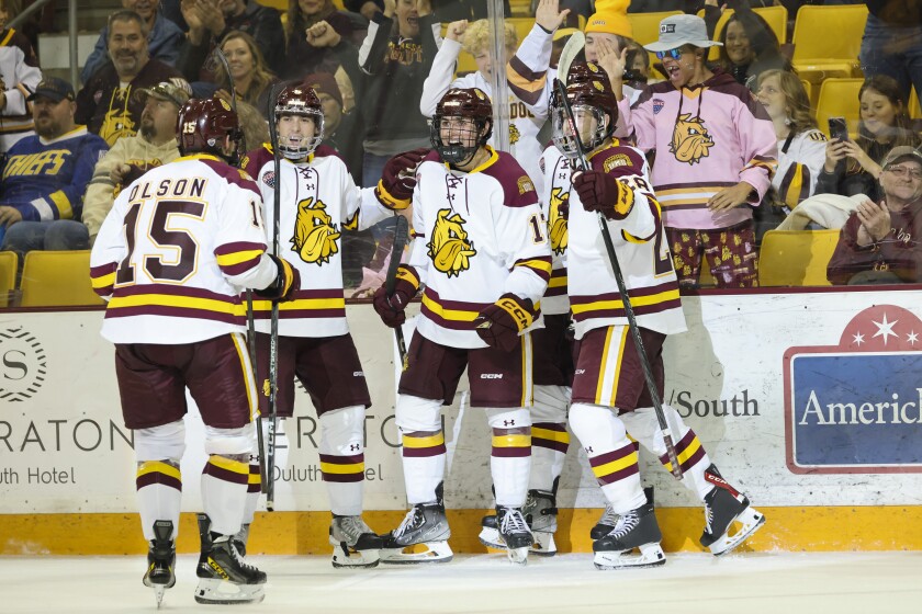 A college hockey player plays in an indoor rink