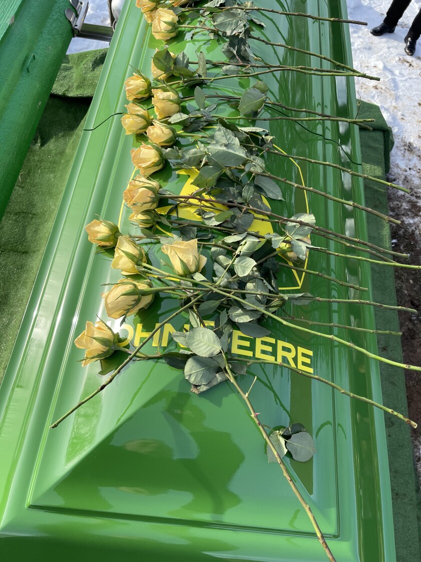 Flowers adorn the custom-made John Deere casket