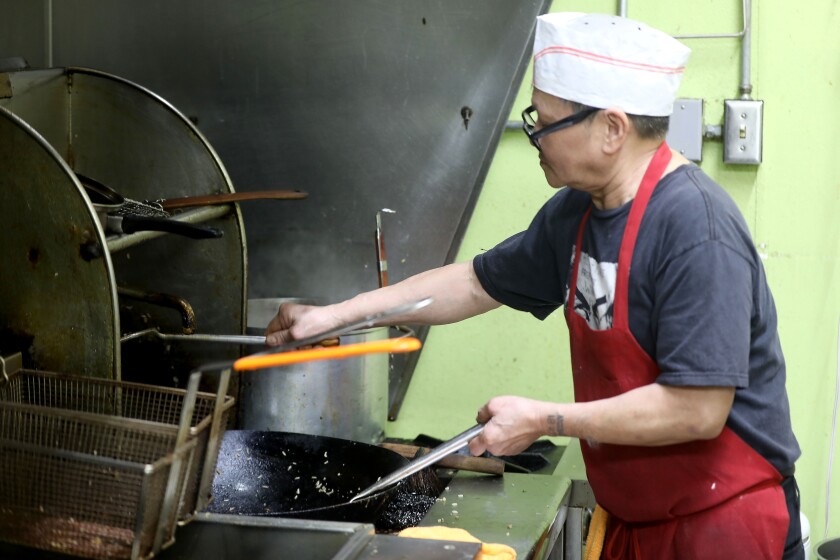 A man preparing to cook in a kitchen.