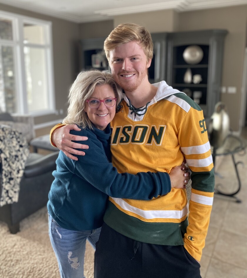 Keatyn Skytland and his mother are shown, smiling, in the family's home in Mandan.