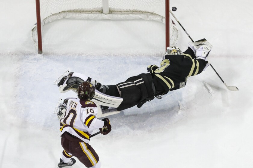 Men's hockey players in black uniforms compete against players in white uniforms at Amsoil Arena