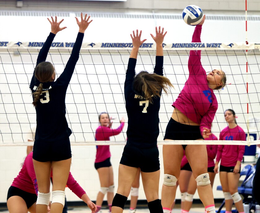 Minnesota West Lady Jays outside hitter Kennedy Buckneberg (20) spikes the ball against Western Technical College Cavaliers Mallory Farr (3) and Maycie Vierck (7) during Friday night's match.