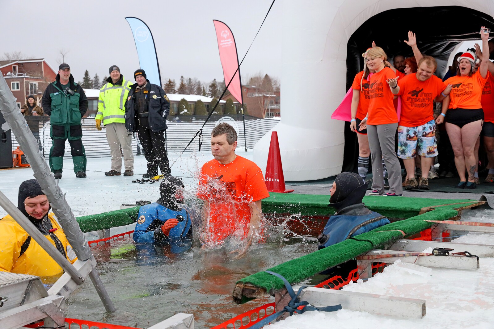 People jump into the water during the Polar Plunge event on Pelican Lake.