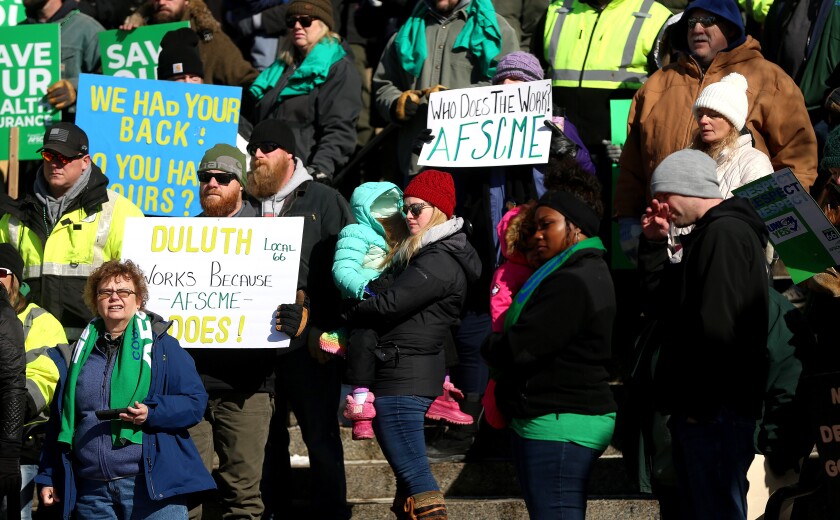 people at a rally holding placards