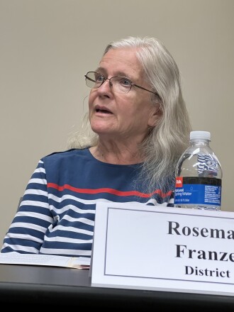 A candidate answers a question while seated at a table