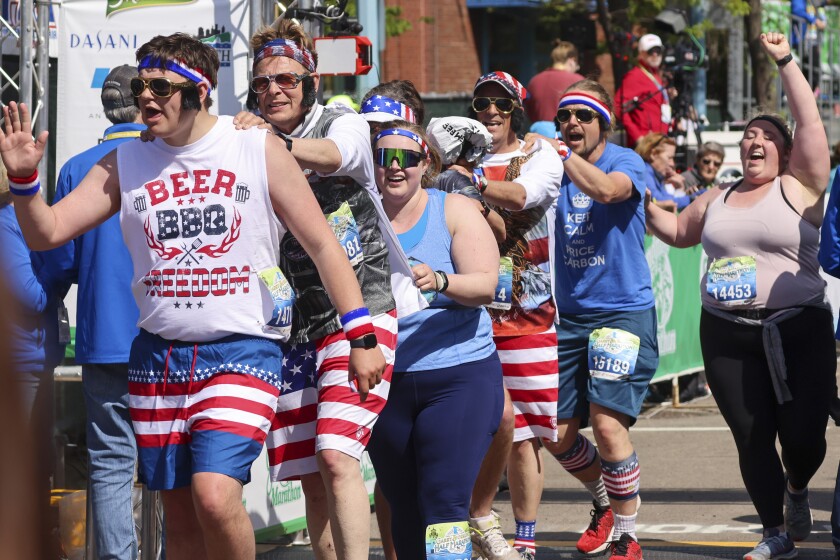 Athletes running and celebrating at the finish line area of Grandma's Marathon