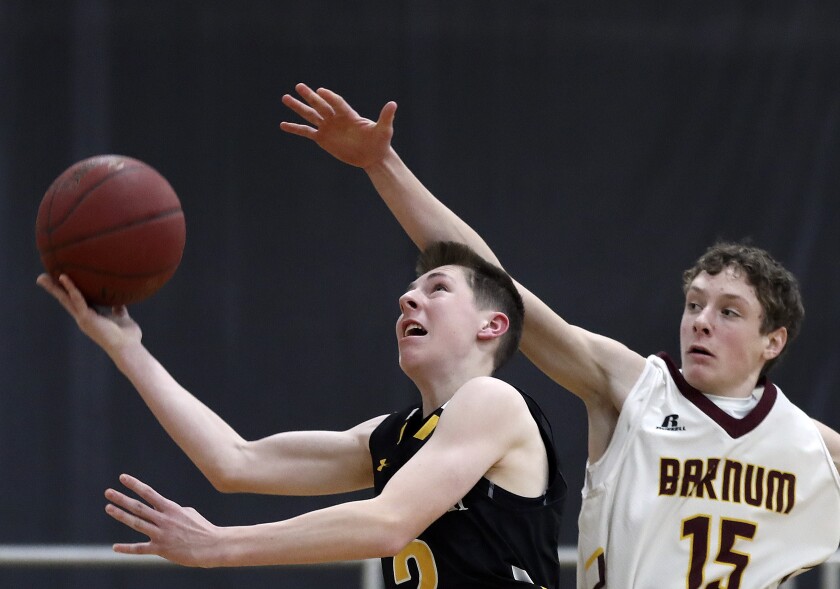 Basketball player attempts a lay up.