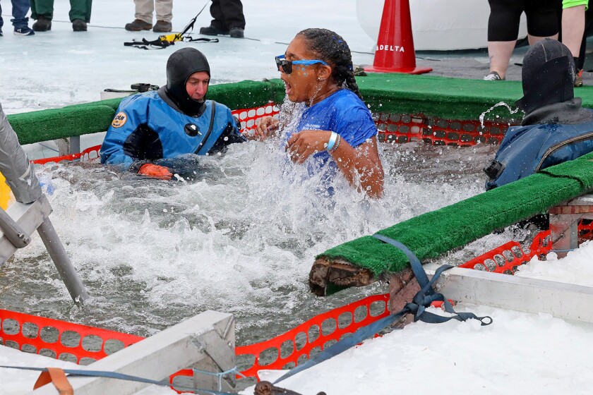 People jump into the water during the Polar Plunge event on Pelican Lake.