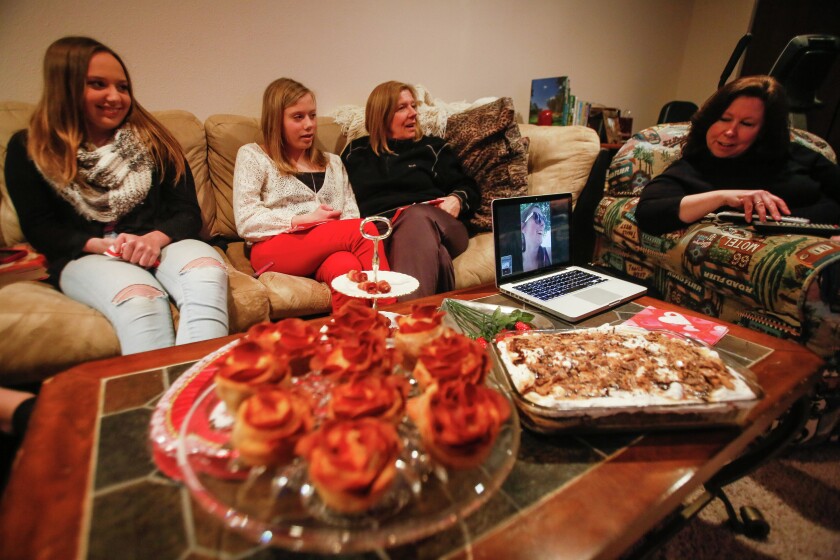 Seated behind some "pepperoni pizza roses" and "Better Than Ben" cake are, from left to right, Katie Staiger, Betsy Staiger, Lisa Staiger and Rose Dunn at her Moorhead home on Tuesday, March 8, 2016. Dunn is speaking with her daughter, Serena, via Skype. The group gathers each week to watch the latest episode of "The Bachelor." Rick Abbott / The Forum