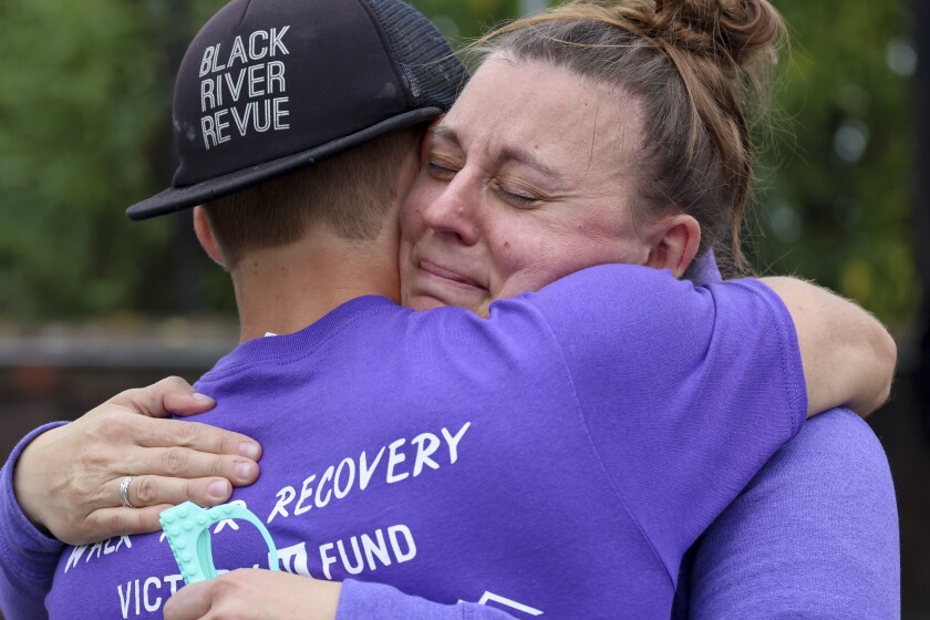 People in purple shirts celebrate recovery in outdoor park