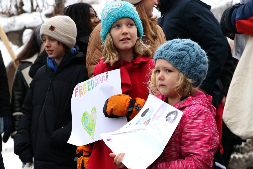 Two kids hold handmade signs.