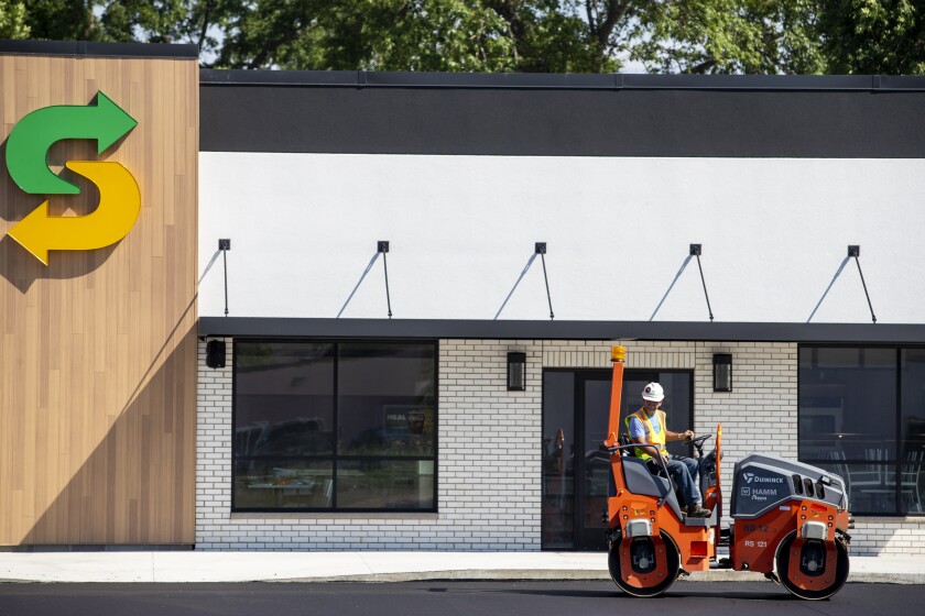 Bob Albertson of Duininck uses a smooth-wheeled roller to put on the finishing touches of a section of parking lot at the new Subway located at 1st Street South on Wednesday, June 29, 2022.
