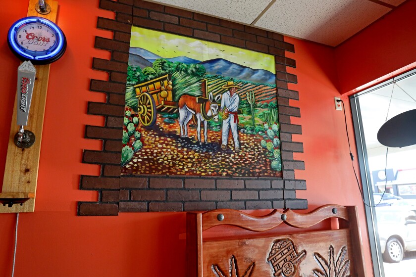 Orange wall with vibrant painting of a man and a donkey