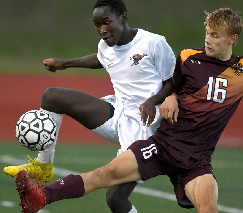 Duluth East’s Pete Onchwari (11) and Duluth Denfeld’s Joshua Rock (16) battle for the ball in the second half