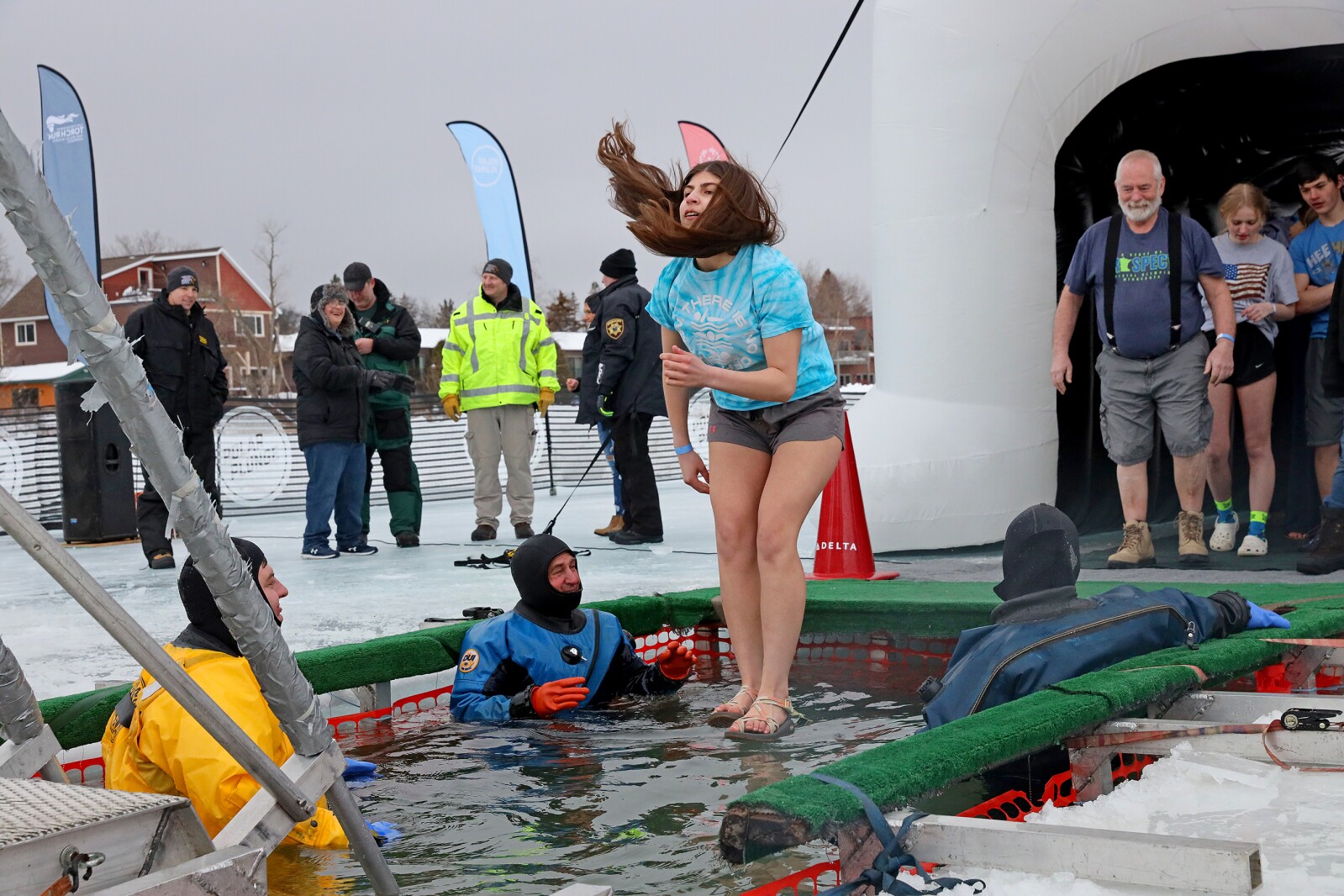 People jump into the water during the Polar Plunge event on Pelican Lake.