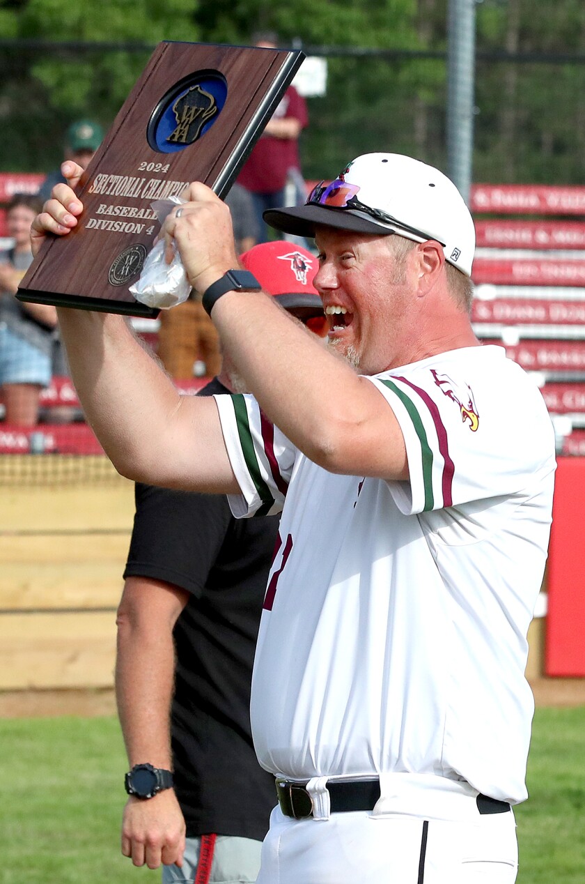 Coach holds section plaque.