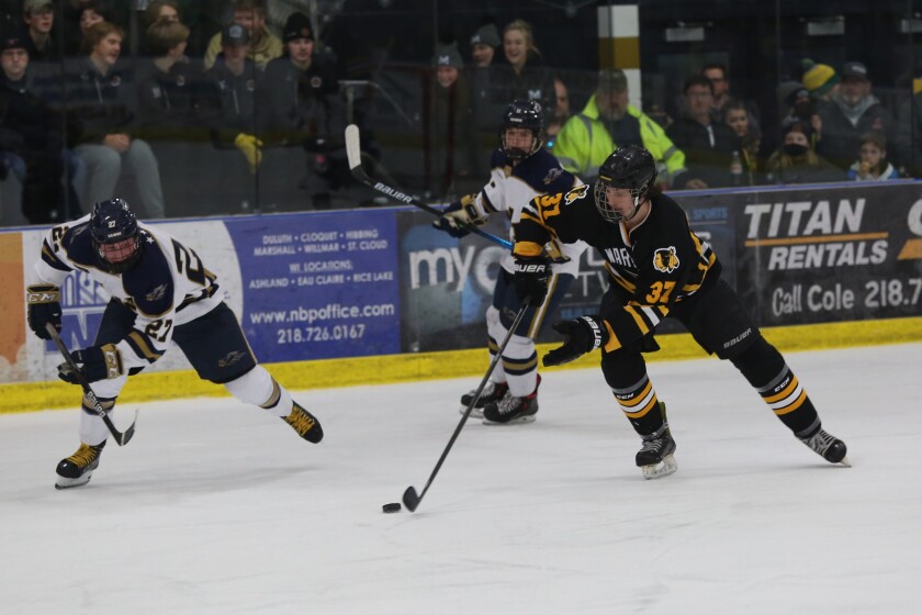 Warroad's Carson Reed, 37, competes for the puck with Hermantown's Zam Plante.