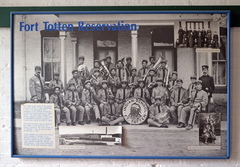 An official photo of a marching band has "Fort Totten Reservation" imposed on it in blue ink.