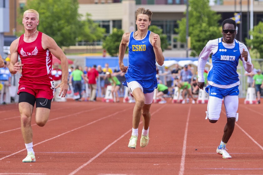 Athletes compete in track and field events at outdoor stadium