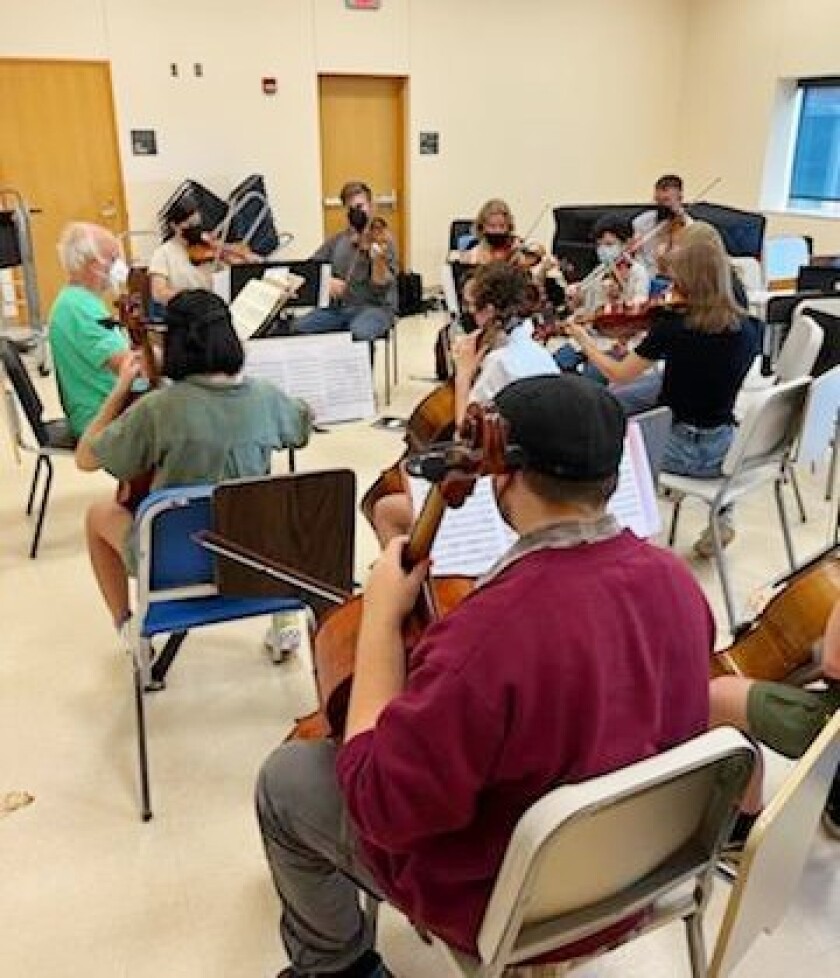 A group of musicians rehearse in a small room.