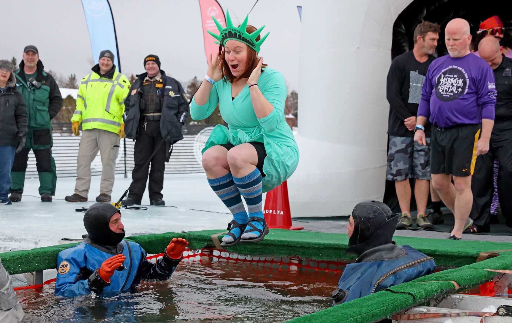 People jump into the water during the Polar Plunge event on Pelican Lake.