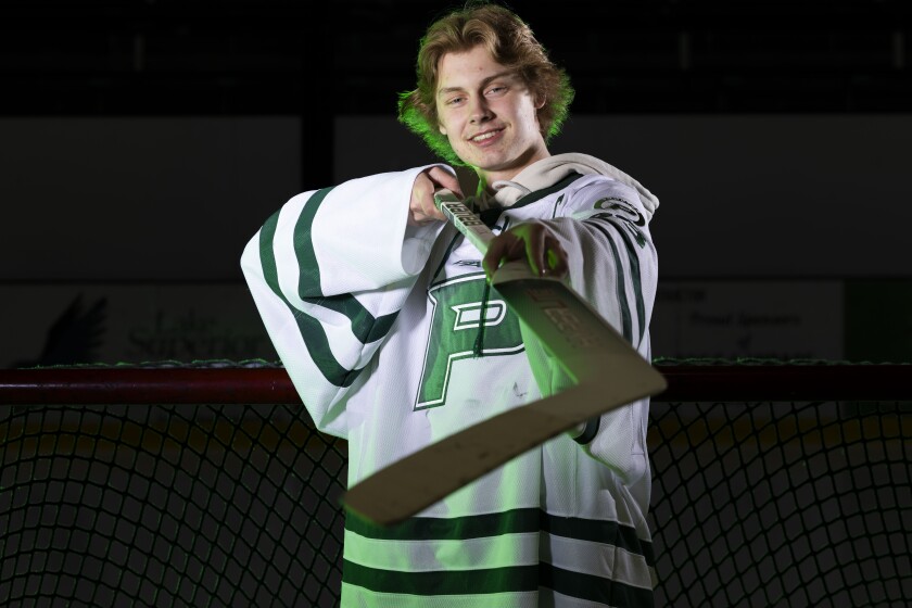 High school hockey player poses with his stick