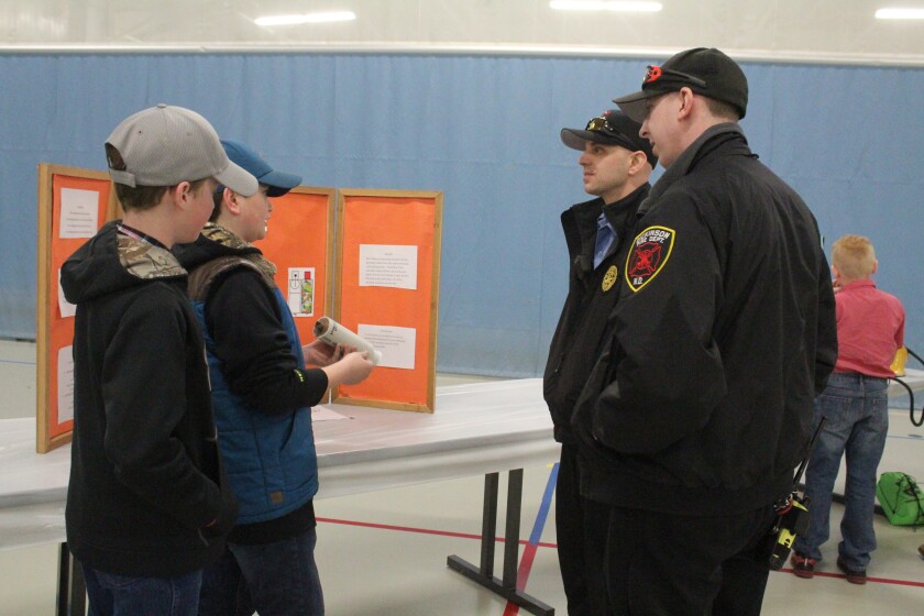 Emmet Reis and Dawsyn Malkowski (left) showcase their "extinguisher grenade" concept to some members of the Dickinson Fire Department, Troy Berger and Brad Banyai. (Iain Woessner/The Dickinson Press)