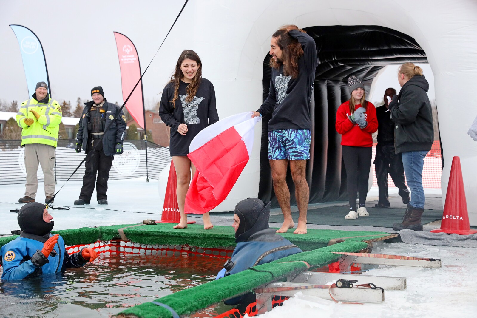 People jump into the water during the Polar Plunge event on Pelican Lake.