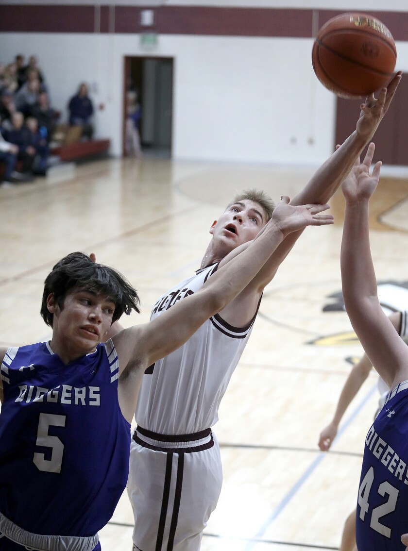 Solon Springs’ Isaiah Kastern (50) grabs a rebound over Mellen’s Ryan Henri (5)