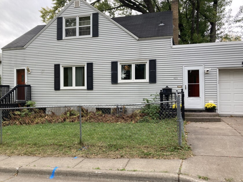 A gray and black house with a chain link fence