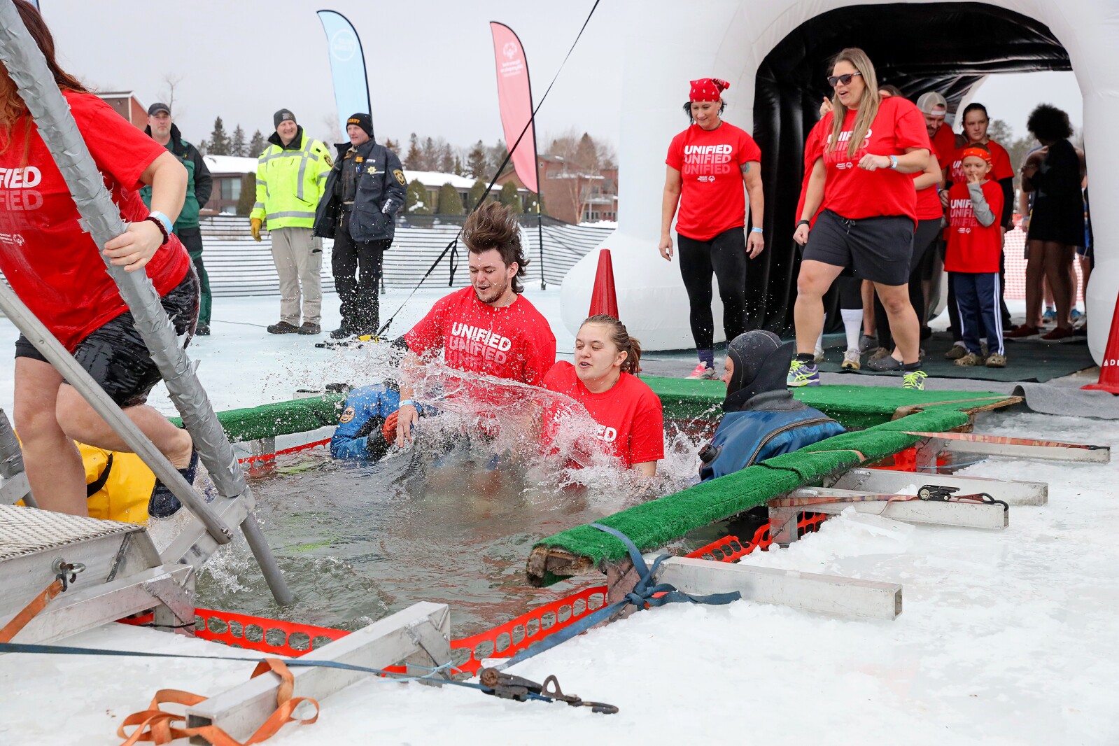 People jump into the water during the Polar Plunge event on Pelican Lake.